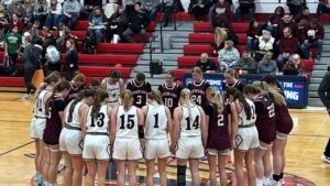 Grand Island Lutheran High School Varsity girl's basketball team pregame prayer with opponent at mid-court.